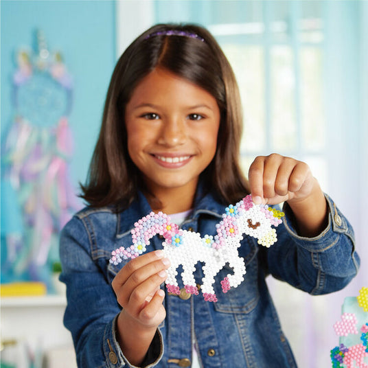 Girl playing with beaded craft kit